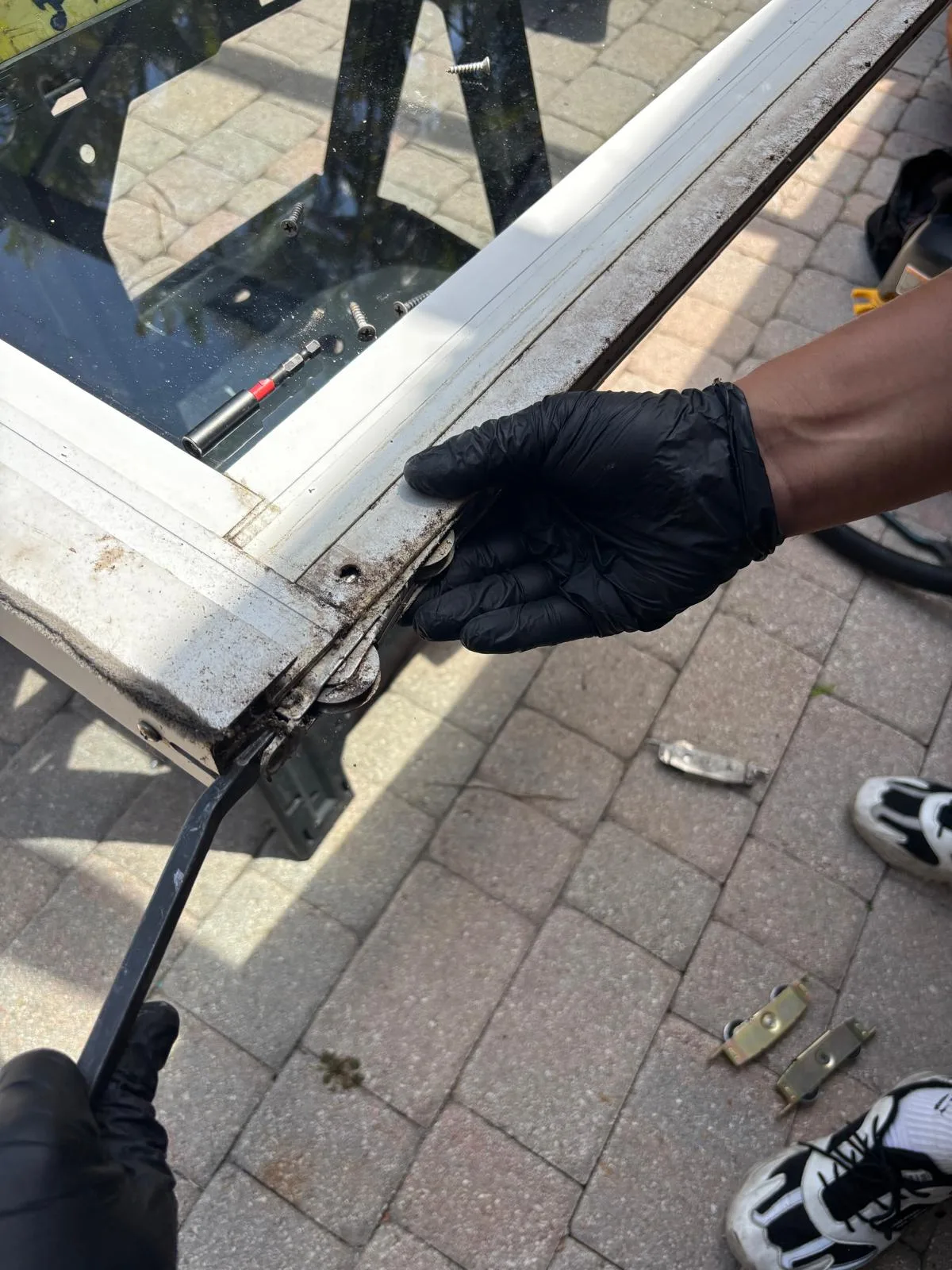 Technician extracting sliding door rollers from frame